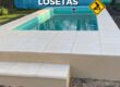 Pileta de fibra con el solado de losetas atermicas terminado, escalon de acceso y revestimiento exterior